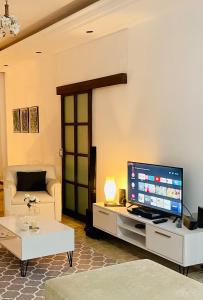 sala de estar con TV y sofá en Nicocreon Guest House en Famagusta