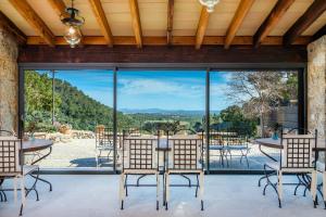 un comedor con grandes ventanas, mesas y sillas en Finca Albellons, en Binibona