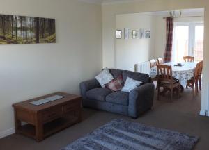 uma sala de estar com um sofá e uma mesa em No 25 Inverness - Home from Home in the Highlands em Inverness