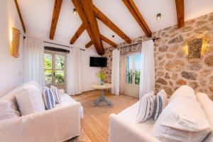 a living room with two white couches and a stone wall at Finca Albellons in Binibona
