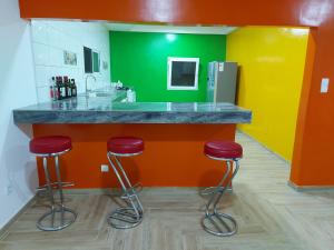 a colorful kitchen with red stools at a counter at Villa Eloy in Lomé