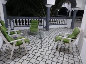 a group of green chairs sitting on a patio at Villa Eloy in Lomé