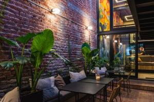 a brick wall with tables and plants in a restaurant at Faz Hostel in Córdoba