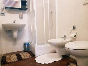 a bathroom with a toilet and a sink at Airport Rooms - Bari in Bari +12 photos