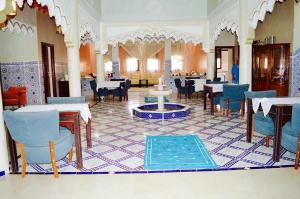ein Restaurant mit Tischen und Stühlen in einem Zimmer in der Unterkunft Riad Sadoq in Merzouga