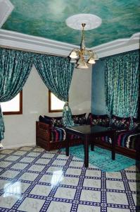 ein Wohnzimmer mit einem Sofa und einem Tisch in der Unterkunft Riad Sadoq in Merzouga