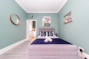 a bedroom with a large bed with blue walls at Stunning STUDIO Apartment in Hove Minuets away to BRIGHTON BEACH in Brighton & Hove