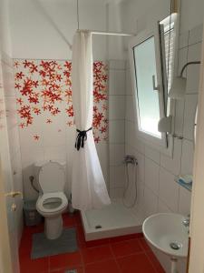 a bathroom with a shower with a toilet and a sink at VILLA ARMONIA GUEST HOUSE in Prinos