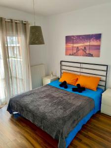 a bedroom with a large bed with orange pillows at VILLA ARMONIA GUEST HOUSE in Prinos