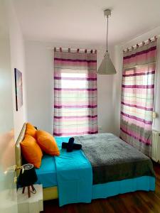 a bedroom with a bed with orange pillows and a window at VILLA ARMONIA GUEST HOUSE in Prinos