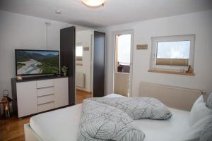 een slaapkamer met een bed en een flatscreen-tv bij Ferienhaus Hochvogel in Hinterhornbach