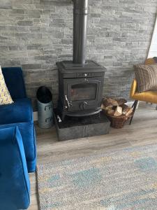 a fireplace in a living room with a blue couch at Glenhill - Newly renovated in a unique location in Belmullet