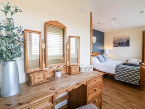 1 dormitorio con 1 cama y vestidor con espejo en Little Gem, en Uttoxeter