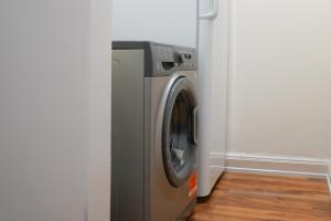 uma máquina de lavar e secar roupa num canto de um quarto em Glasgow - 2 Bedroom Apartment em Glasgow