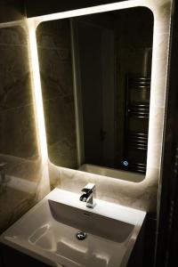 lavabo en el baño con un espejo grande encima. en Glasgow - 2 Bedroom Apartment, en Glasgow