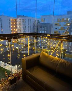 eine Couch auf dem Balkon mit Beleuchtung in der Unterkunft New condo with free parking 10 min from Helsinki Airport in Vantaa