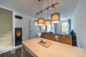 a dining room and living room with a table and a fireplace at Meerblick 43 in Wangerland