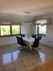 a dining room with a white table and chairs at Apartman Tomislav in Tomislavgrad