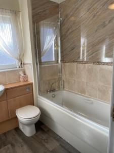 uma casa de banho com um WC, uma banheira e um lavatório. em No 25 Inverness - Home from Home in the Highlands em Inverness
