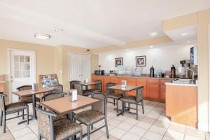 a restaurant with tables and chairs and a kitchen at OYO Hotel Tulsa International Airport in Tulsa