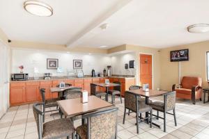 a restaurant with tables and chairs and a kitchen at OYO Hotel Tulsa International Airport in Tulsa