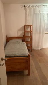 1 dormitorio con cama de madera y ventana en Inspiratio Domum en Weyarn