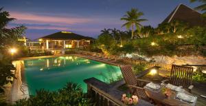 a swimming pool in a resort at night at Mithi Resort & Spa in Panglao