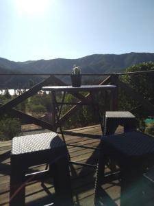 une table et deux chaises sur une terrasse avec vue dans l'établissement lliulliunewen, à Limache