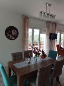 a dining room table with chairs and a bottle of wine at Holiday home Buljat in Kaštela