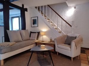 a living room with a couch and chairs and a staircase at Maison d'Engon charme nature in Beauraing