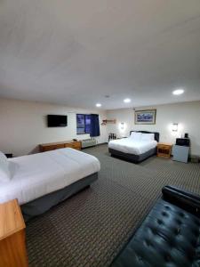 a hotel room with two beds and a flat screen tv at Hibbing Inn & Suites in Hibbing