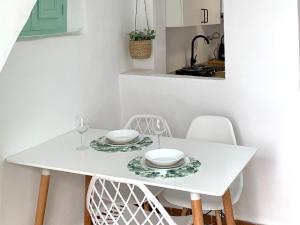 een witte eettafel met twee witte gerechten erop bij Casita Menta - Alojamiento único en el Centro de Torrox in Torrox