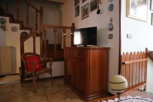 a living room with a television on a wooden cabinet at Casa Angela a Follina in Follina