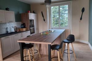 una cocina con una gran mesa de madera y sillas en Location maison, en Ally