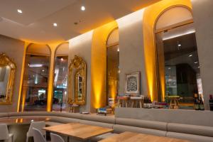 リスボンにあるDos Reis by The Beautique Hotelsの黄色の壁とテーブルと鏡が特徴のレストラン