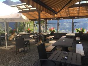 a restaurant with tables and chairs with mountains in the background at Hotel Bellavista Cavigliano in Cavigliano