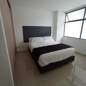 ein Schlafzimmer mit einem Bett in einem Zimmer mit einem Fenster in der Unterkunft New Beautiful Apartment in the Heart of LAURELES 402 in Medellín