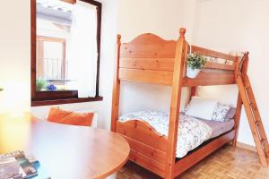 Litera de madera en habitación con mesa en Arco Felix, en Arco