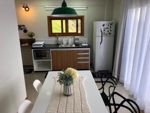 een keuken met een witte tafel en een koelkast bij Recanto dos Ipês 2 in Domingos Martins