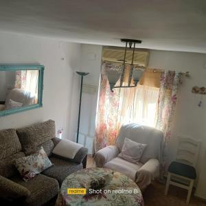 a living room with a couch and a chair at El Cordobes in Córdoba