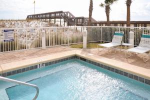 einen Pool mit zwei Stühlen und einem Zaun in der Unterkunft Caribbean Resort 1101 in Navarre