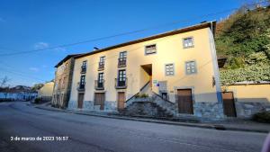 um edifício branco ao lado de uma rua em Apartamentos Rurales Casa Ardaliz em Cangas del Narcea
