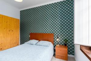 a bedroom with a bed and a green wall at Renov Mar23 Clerigos Premium with self check in in Porto