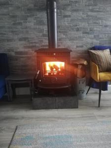 um fogão a lenha numa sala de estar com um sofá em Glenhill - Newly renovated in a unique location em Belmullet