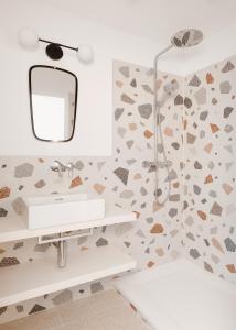 een badkamer met een wastafel en een spiegel bij Urban Inn - Wilten 24/7 in Innsbruck