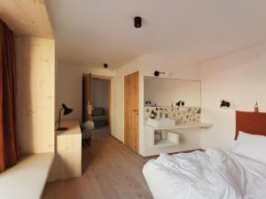 a bedroom with a bed and a desk and a mirror at Urban Inn - Wilten 24/7 in Innsbruck