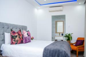 - une chambre avec un grand lit blanc et des oreillers violets dans l'établissement Golfview luxury apartment, à Richards Bay