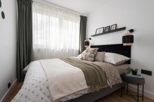 a bedroom with a large bed and a window at Apartament Amber - darmowy Parking, ścisłe centrum - by Kairos Apartments in Gliwice