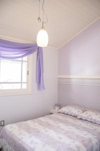 a bedroom with a bed with a purple curtain at Cobertura na Borges de Medeiros - ( 3 quadras rua coberta ) in Gramado