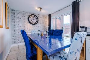 a dining room with a blue table and chairs at Platt House 